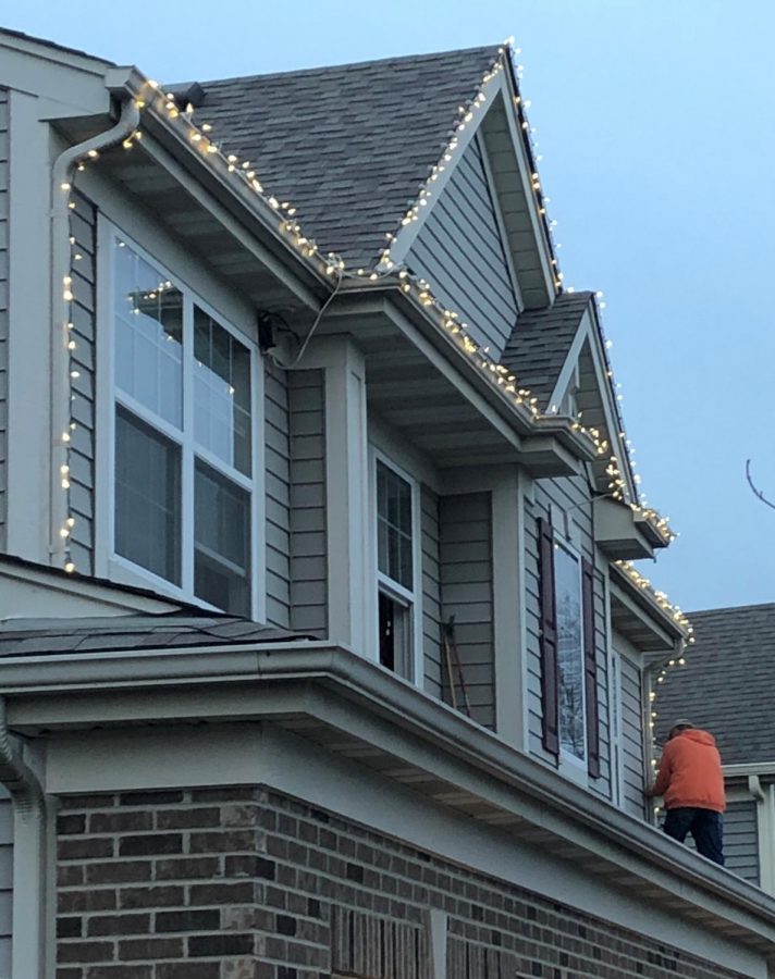 A Plainfield resident puts up lights around his house in November
