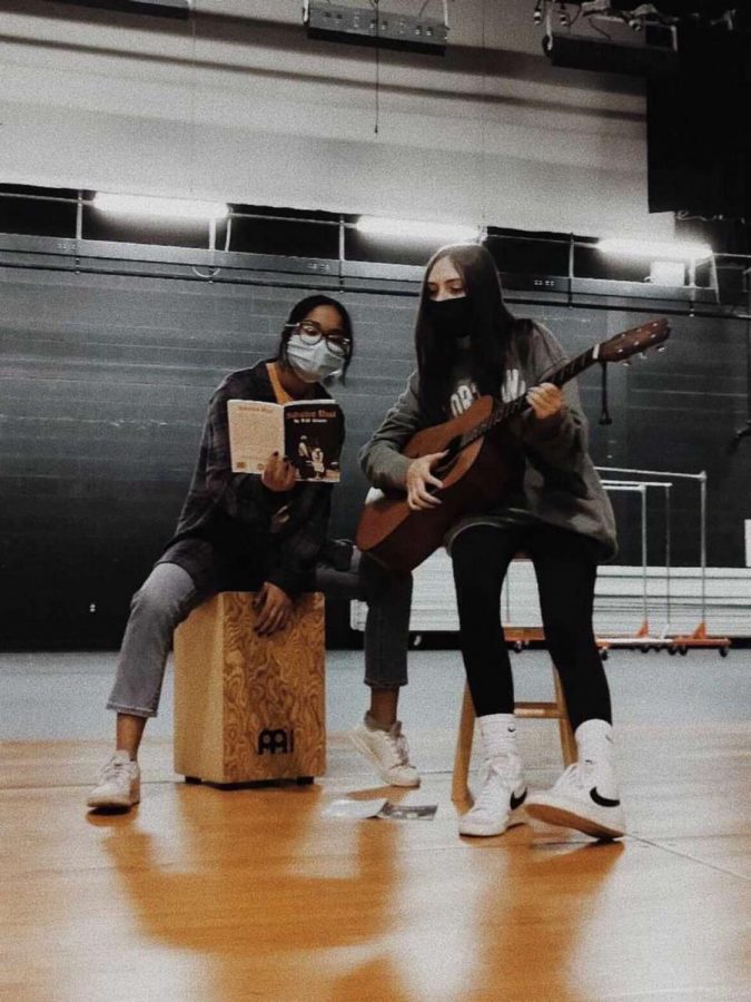 Freshmen Jade Gumila and sophmore Nina Powley rehearse their original son written for the play "Salvation Road" Photo courtesy of Shyla Singer