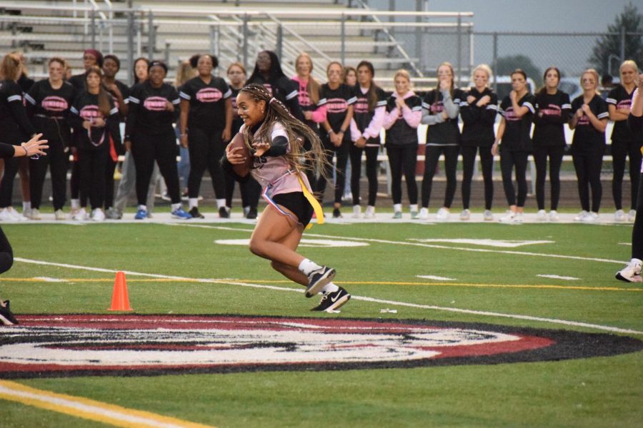 Senior Nina Bradshaw jukes juniors to get to the endzone in the powderpuff match on Oct 6. Photo by Nicole Posont