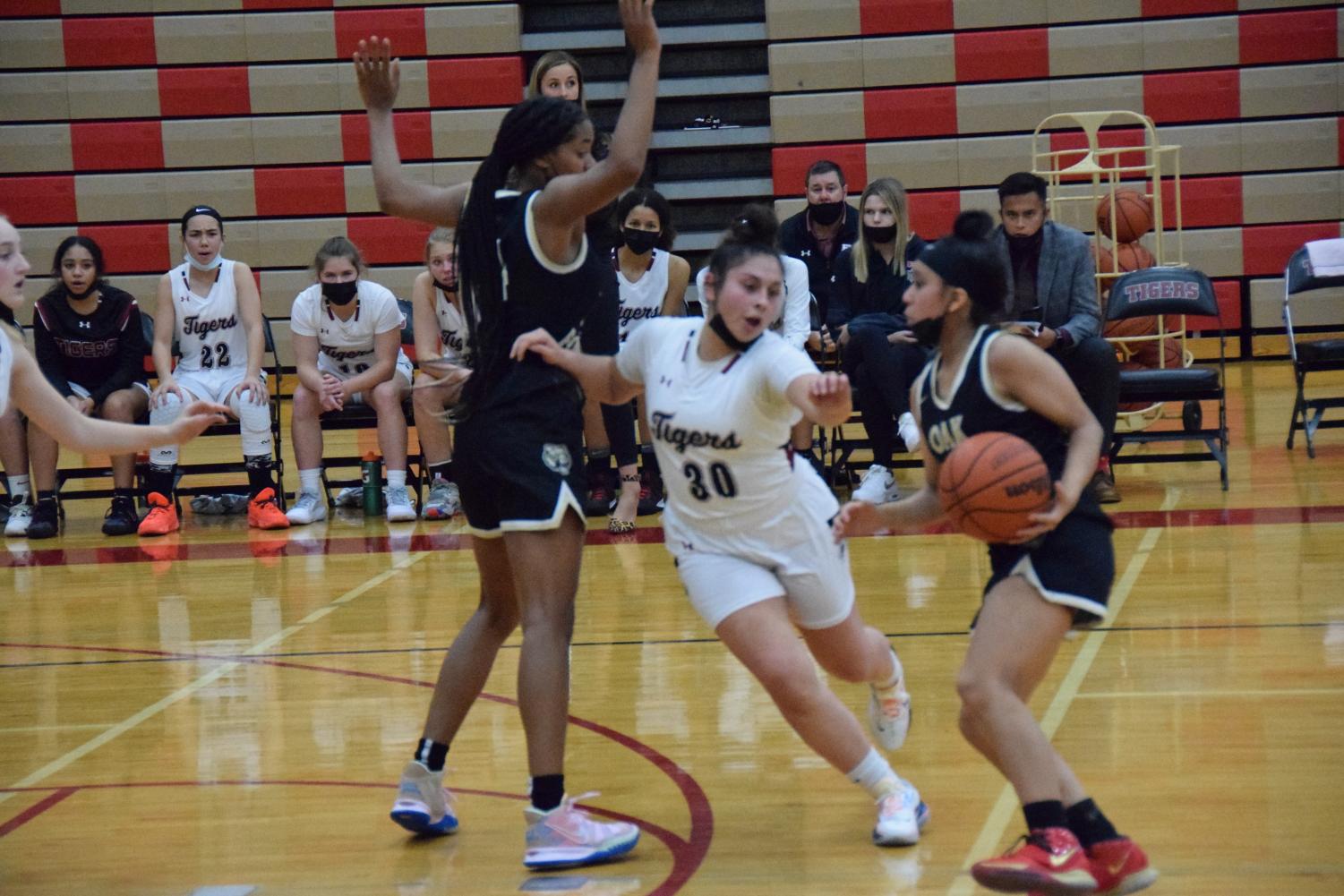 Junior point guard Lexi Salazar drives off of screen set by junior power forward Ruby Davis during the match against Oak Forest on Nov. 16. Photo By Julia Gerard
