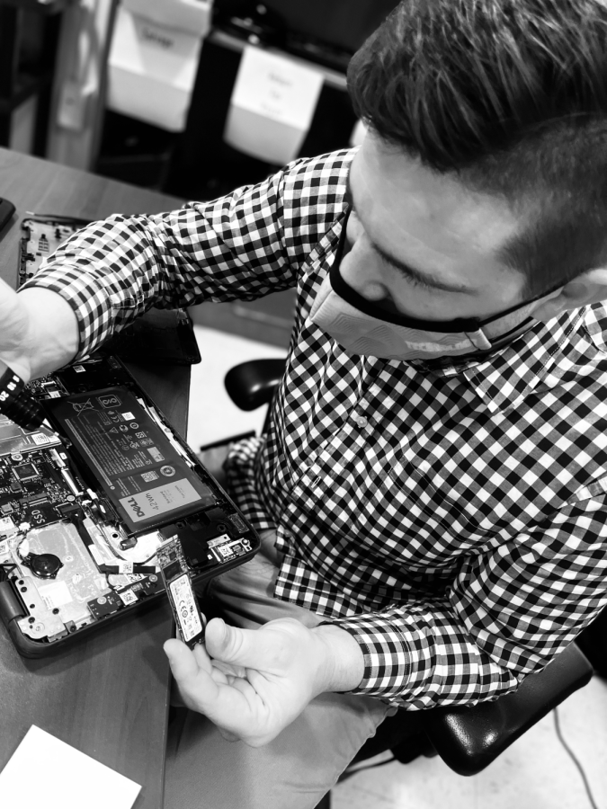 Technology support specialist Tim Gunier replaces the hard drive on a students broken laptop. Photo by Alex Eydenberg