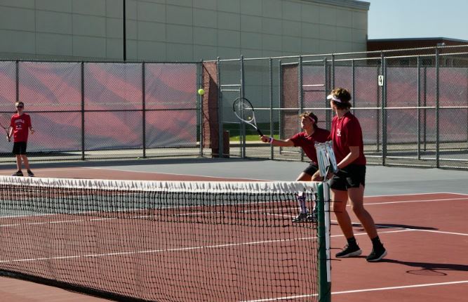 Junior Joey Cecchi (left) gets ready to hit the ball with teammate junior Ben
Cummings (right) during practice. Photo by Nick Powell