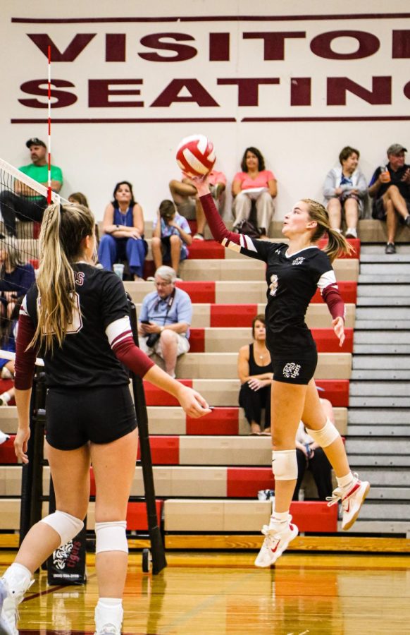 Senior Christina Petkus (right) tips the ball to continue a Tiger rally against Wheaton North on Aug. 23.