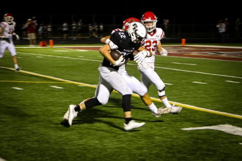 Senior running back John St. Clair fights for extra yardage on a 23-yard run, a highlight from North’s 19-9 win over Naperville Central on Sept. 2.