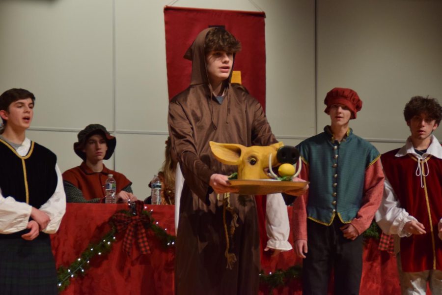 Freshman Evan Ruggirello offers a boar’s head to the crowd during Bassics the performance. 