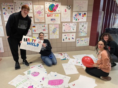 Seniors Logan Rooney, Allison Smith, Teagan Cushall, and ASL teacher Emily Pomrening decorate the ASL hallway. Photo by Alex Barlog